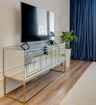 extremely large screen television on glass storage cabinet