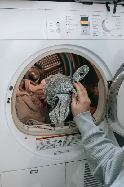person pulling clothers out of dryer